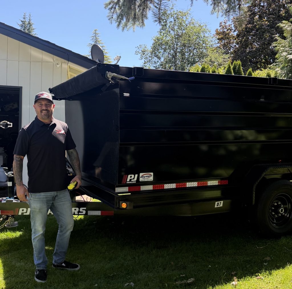 Ian Koons, owner of Best Roofing USA, beside the company trailer